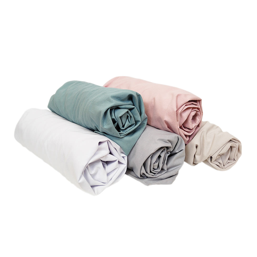 Prześcieradła dziecięce w różnych kolorach ułożone na łóżku